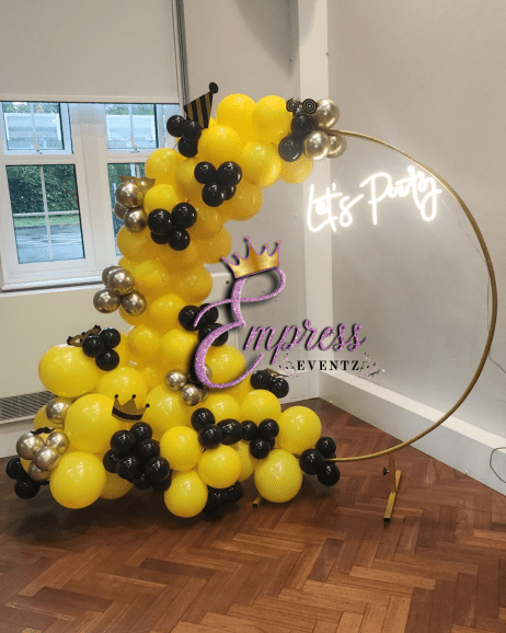 Neon party signs and balloon hoops create a beautiful display for any event